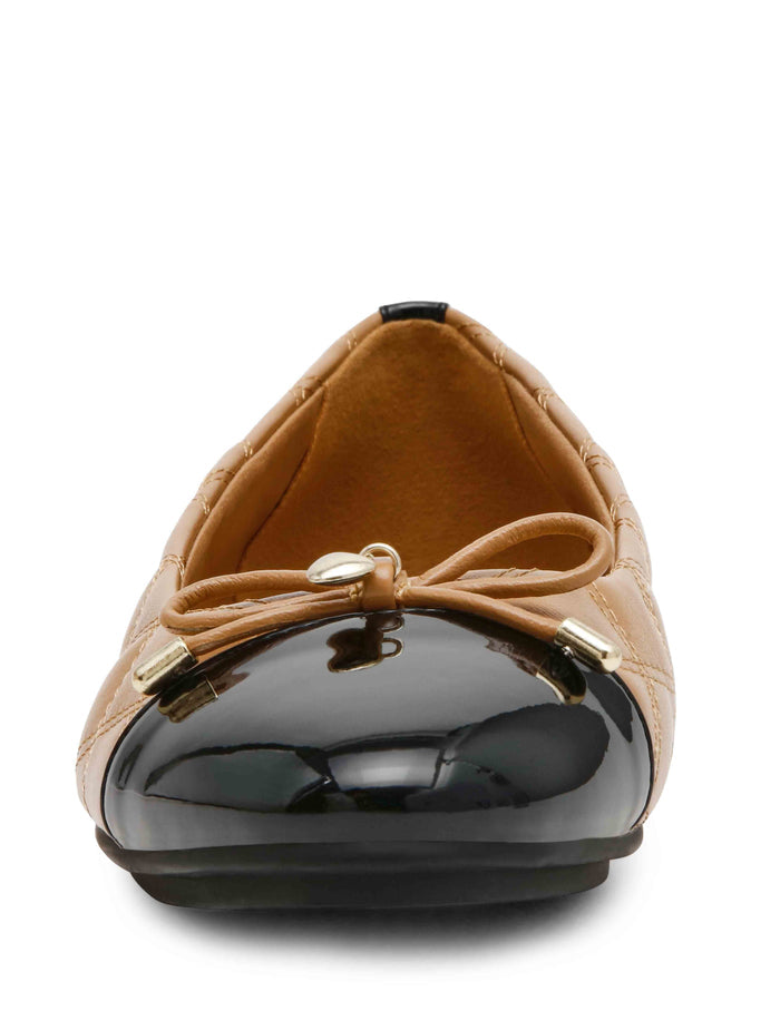Tan quilted leather ballet flat with black patent cap toe, bow detail, and gold hardware accents