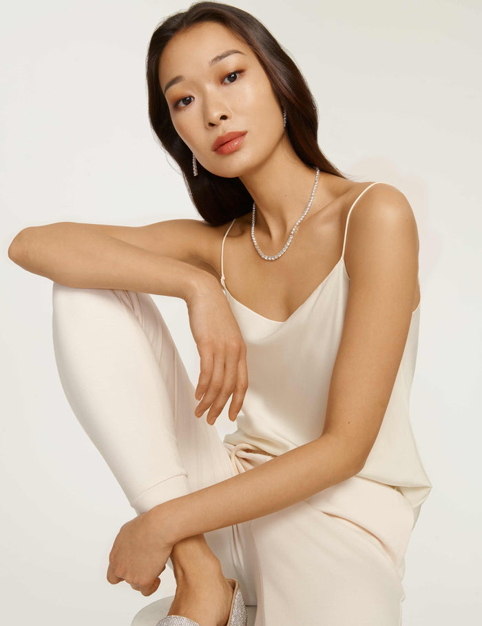 Anne Klein silver-tone prong-set round clear glass stone collar necklace worn against a V-neckline, 16-inch length